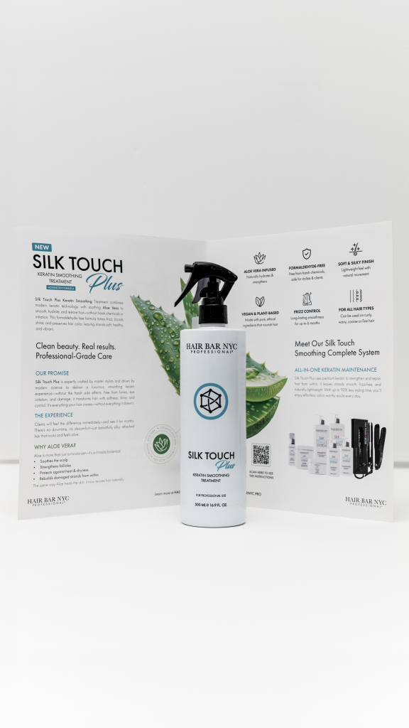 A bottle of Silk Touch Plus Keratin is positioned in front of an open brochure that showcases its product information and benefits.