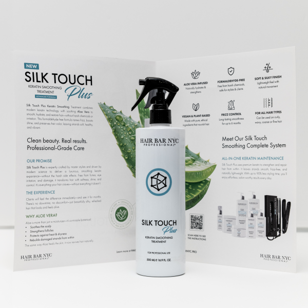 A bottle of Silk Touch Plus Keratin is positioned in front of an open brochure that showcases its product information and benefits.