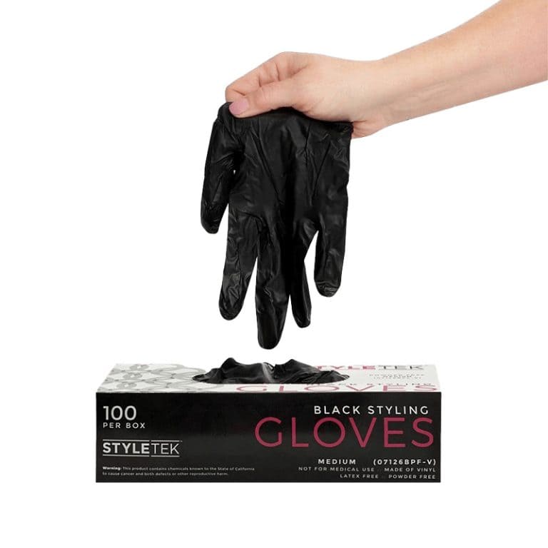 A hand pulls a black glove from a box labeled "Black Deluxe Vinyl Gloves - Powder Free, 100 per box, Medium," highlighting these professional-ready gloves.