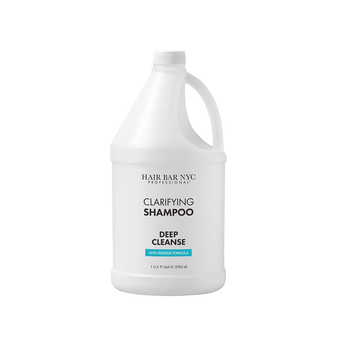 A large white gallon bottle labeled "Clarifying Shampoo Gallon" with a handle and a white cap.