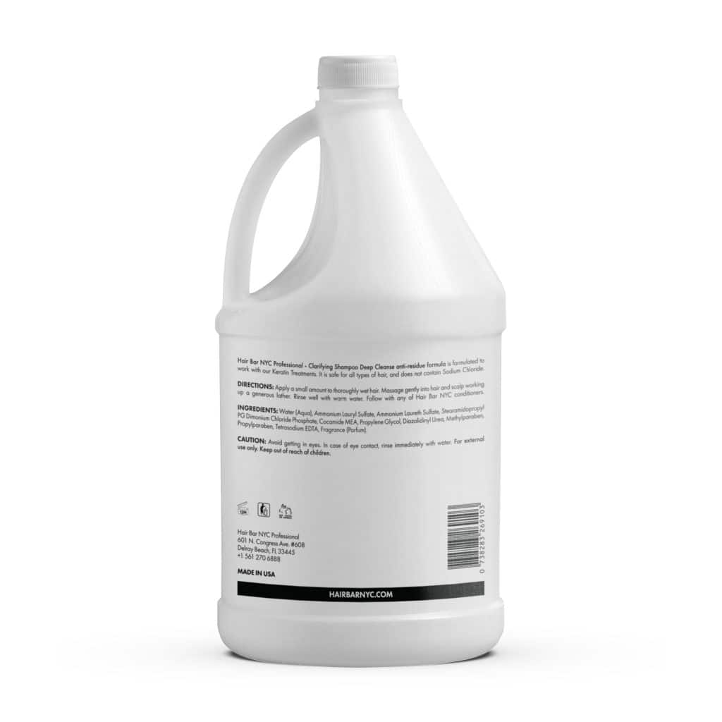 A gallon jug of Clarifying Shampoo with a handle, made of white plastic, featuring a back label listing directions, ingredients, and caution text.
