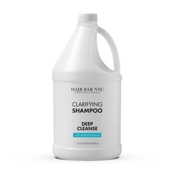 A one-gallon white plastic jug of Clarifying Shampoo Gallon by Hair Bar NYC, featuring a handle and a printed front label.