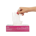 A hand pulls a clear disposable glove from a pink and white box labeled "Clear Deluxe Vinyl Gloves – Powder Free, 100 gloves per box.