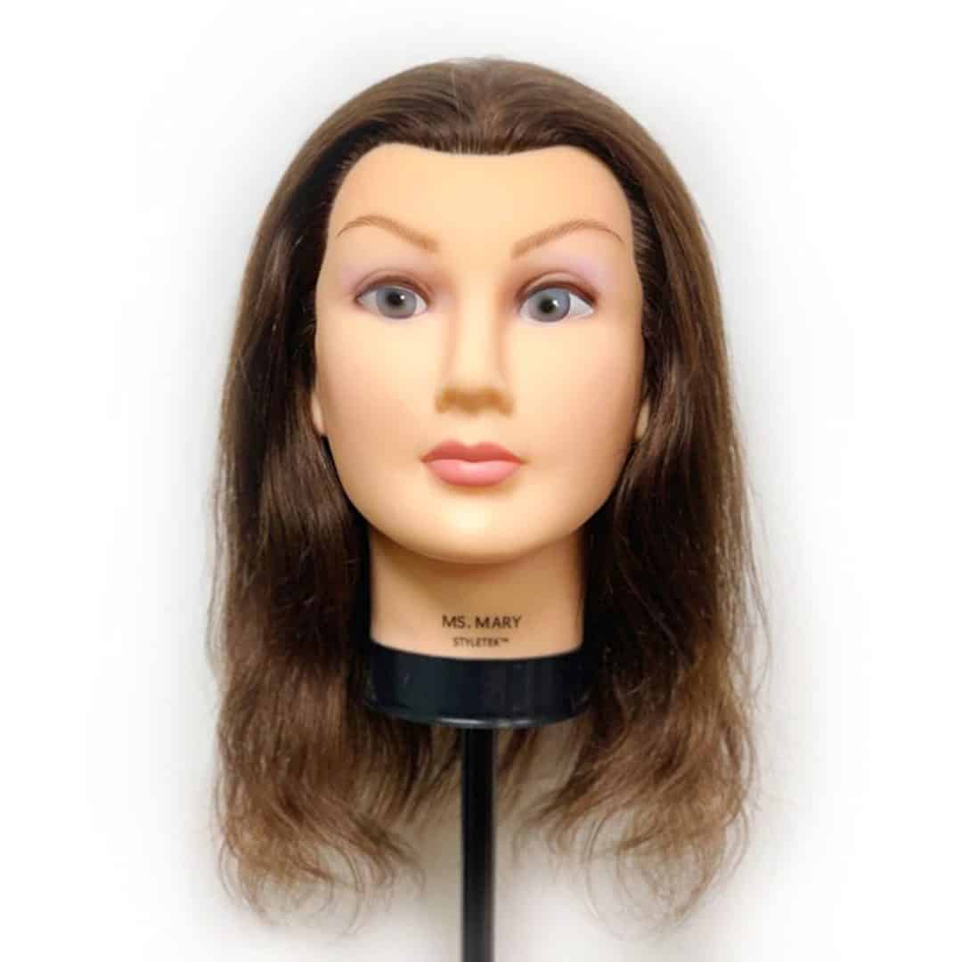 The Deluxe Mary Mannequin features medium-length brown hair, neutral facial features, and comes mounted on a black stand labeled "MS. MARY STYLIST.