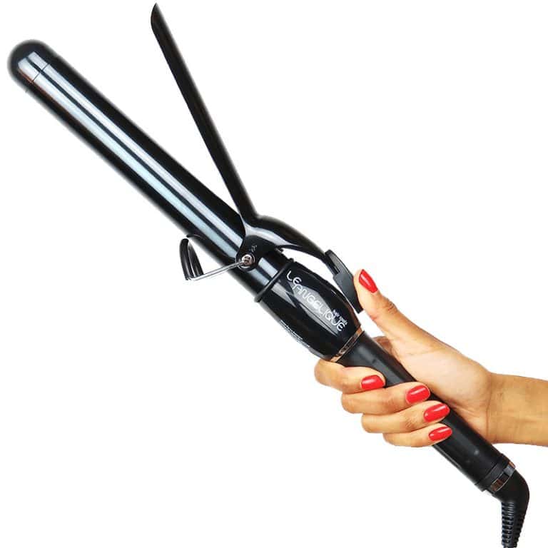 A hand with red-painted nails holds the Ultimate Pro Clip Curling Iron 1", its sleek black and silver body gleaming as the brand name stands out on the handle.