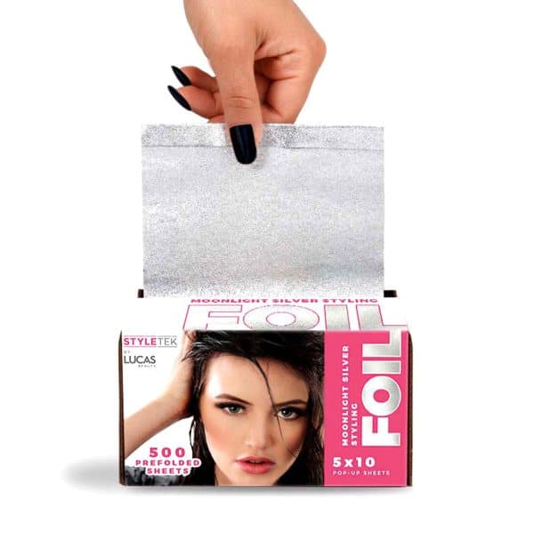 A hand pulls a silver foil sheet from a box labeled "Pop Up Foil 5 x 11 - Heavy Emboss (500CT)" featuring an image of a woman and text stating 500 prefolded sheets, size 5x11.