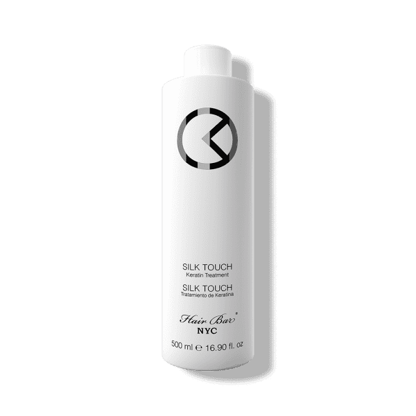 A 500 ml white bottle of Silk Touch Keratin with black text and a circular logo on the upper half.