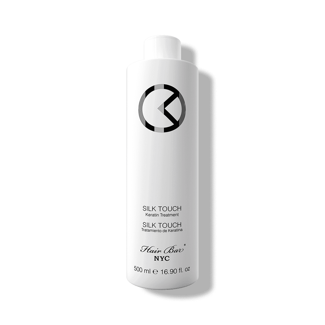 A 500 ml white bottle of Silk Touch Keratin with black text and a circular logo on the upper half.