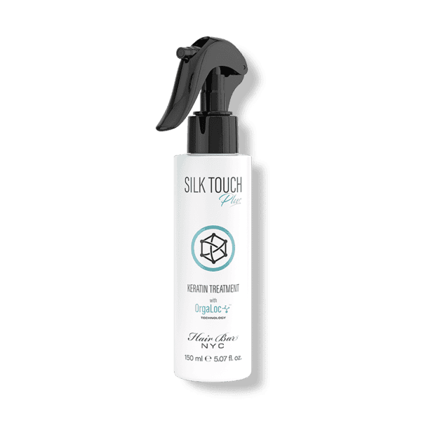 A white spray bottle labeled "Silk Touch Plus Keratin" by Hair Bar NYC, 150 ml (5.07 fl oz), features a black spray nozzle.