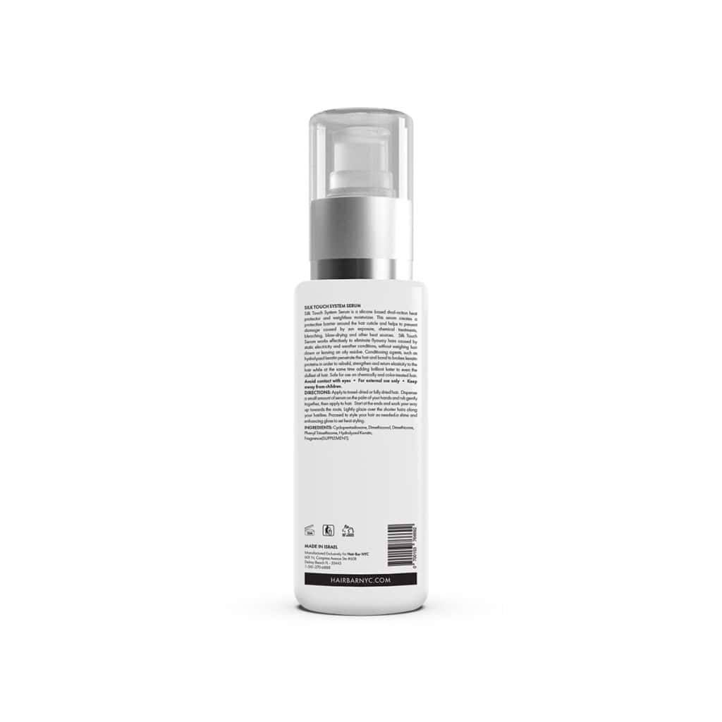 A white bottle with a pump dispenser, shown from the back, features black text displaying Silk Touch System Conditioner details and usage instructions.