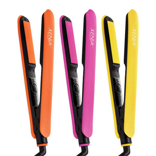 Three Fairytale Bliss Flat Iron 1" hair straighteners in orange, pink, and yellow stand upright side by side on a white background.
