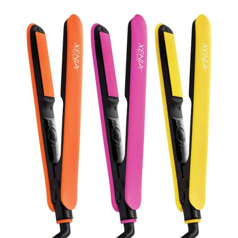 Three Fairytale Bliss Flat Iron 1" hair straighteners in orange, pink, and yellow stand upright side by side on a white background.