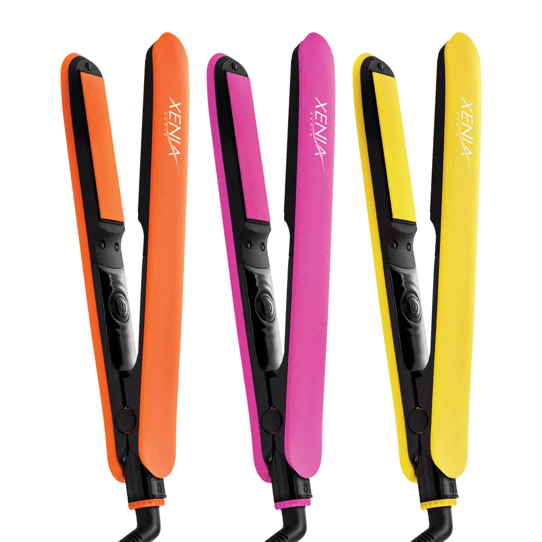 Three Fairytale Bliss Flat Iron 1" hair straighteners in orange, pink, and yellow stand upright side by side on a white background.