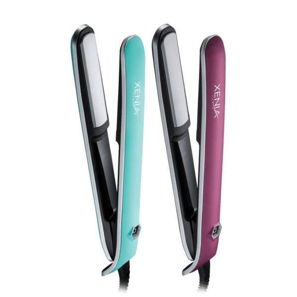 Two Xenia Sleek Flat Iron 1" hair straighteners, one teal and one maroon, stand upright side by side with their plates open and facing forward.