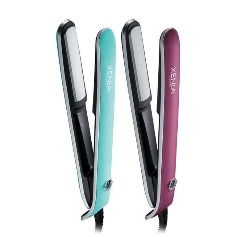 Two Xenia Sleek Flat Iron 1" hair straighteners, one teal and one maroon, stand upright side by side with their plates open and facing forward.