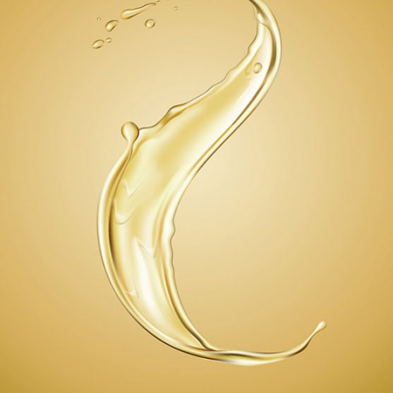 A splash of golden liquid suspended in mid-air against a plain light gold background.