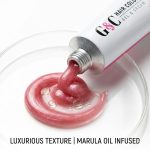 An open tube of G&C 99.0 / 9.NN - Very Light Natural Blonde Intense hair color gel and cream dispenses shimmery pink product onto a clear dish; text reads "Luxurious Texture | Marula Oil Infused.